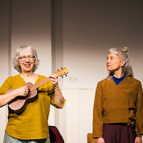 Bild: Zwei Frauen falten sich  - Bewegt Altern